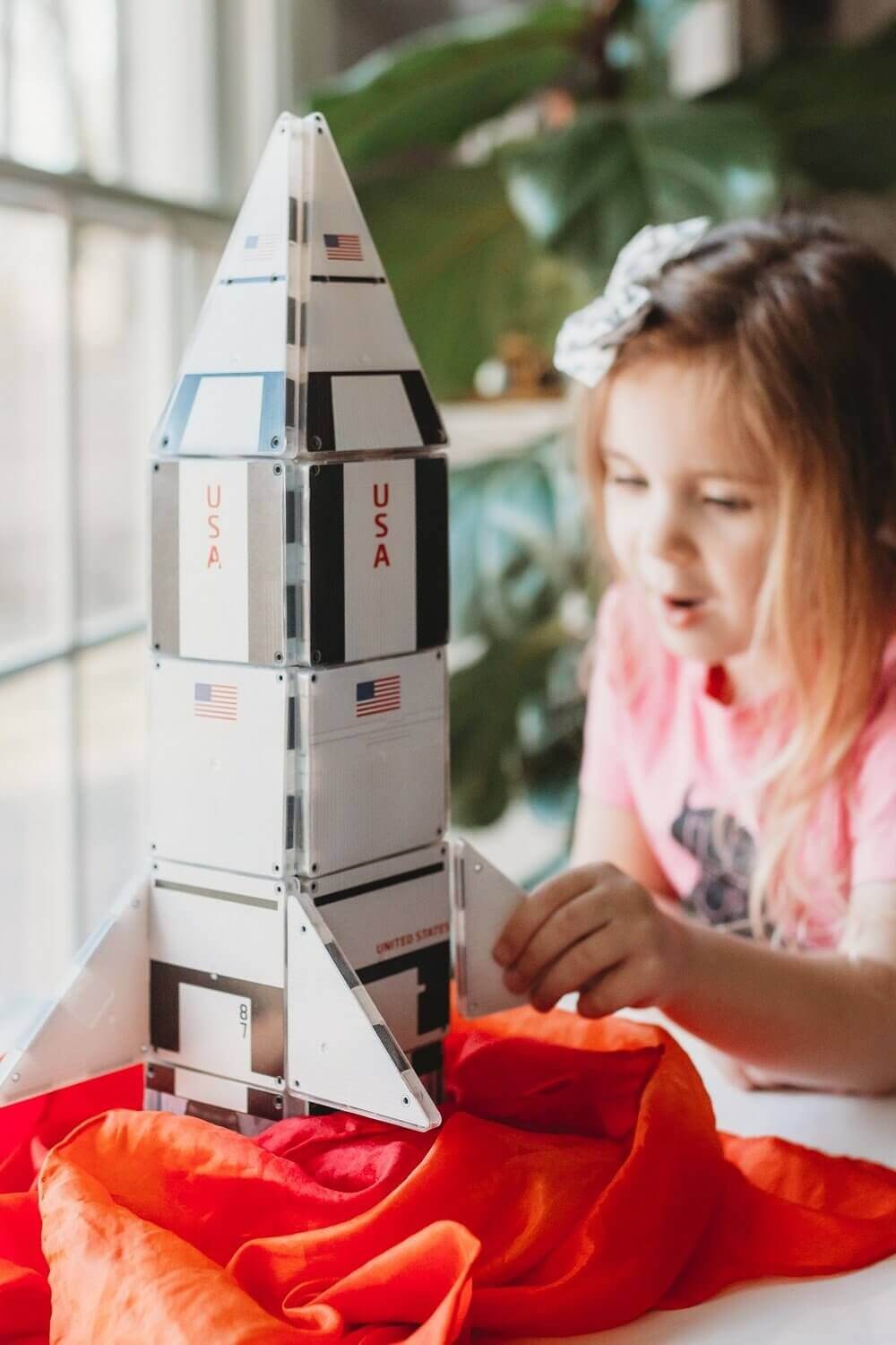 Little girl building a space shuttle with Magna-Tiles Structures