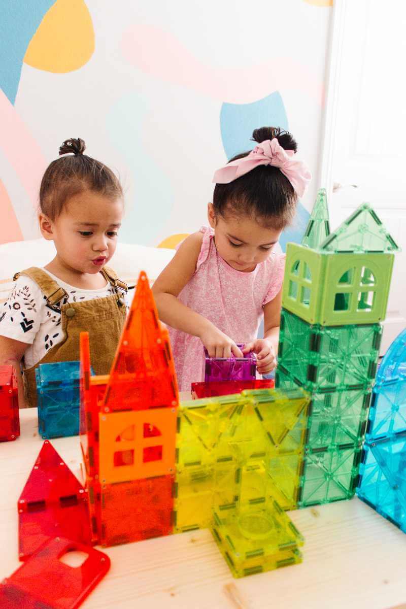 Two girls building with Magna-Tiles