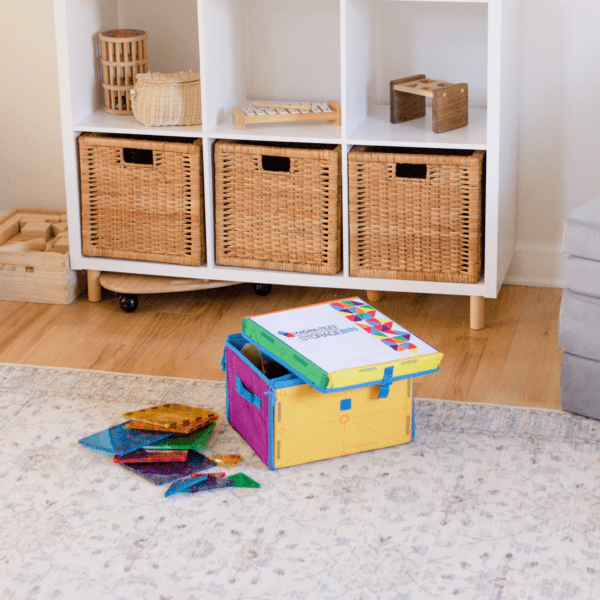 Pile of MAGNA-TILES® sitting on floor next to the 2-in-1 Storage Bin & Interactive Play-Mat