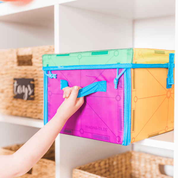 Child taking MAGNA-TILES® Storage Bin down from shelf