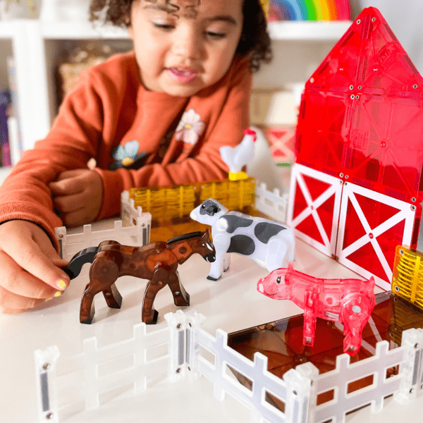 Young girl playing with horse from MAGNA-TILES® Farm Animals 25-Piece Set