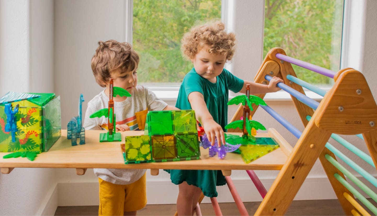 Two young boys playing with MAGNA-TILES® Dino World XL 50-Piece Set